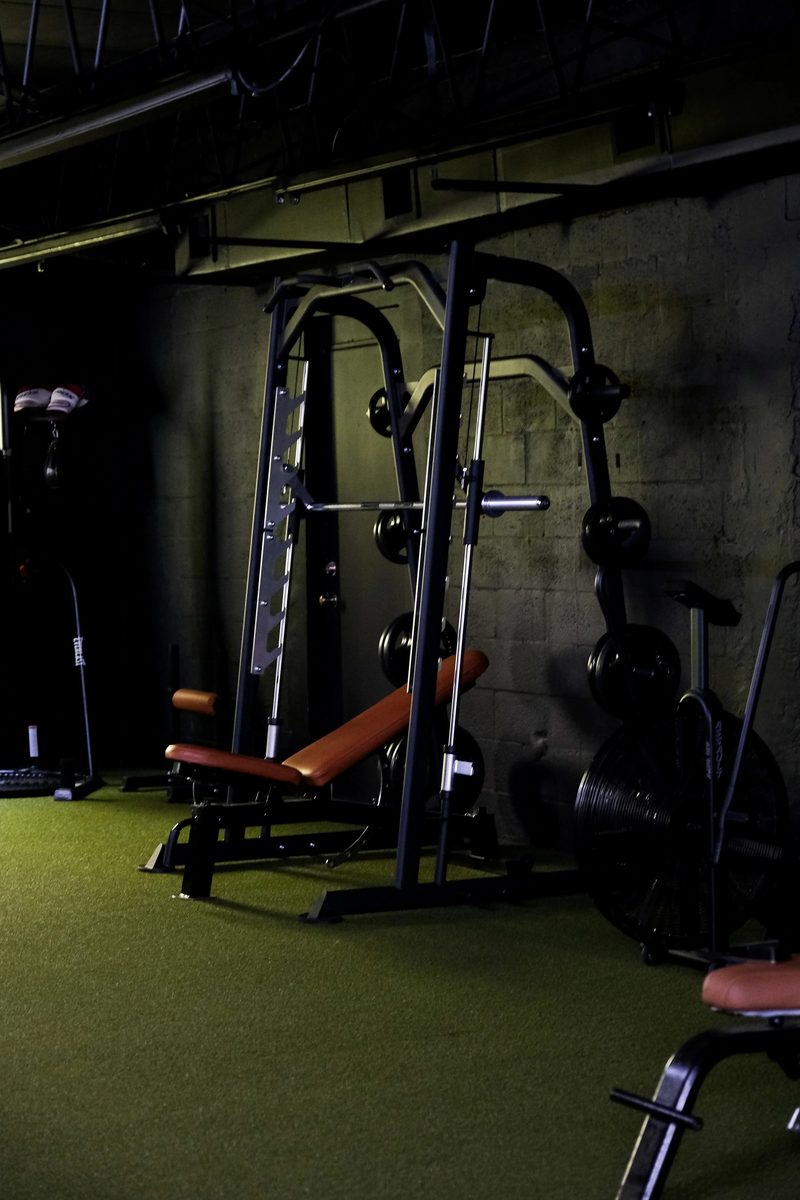 A rack and incline bench on turf lit from the side